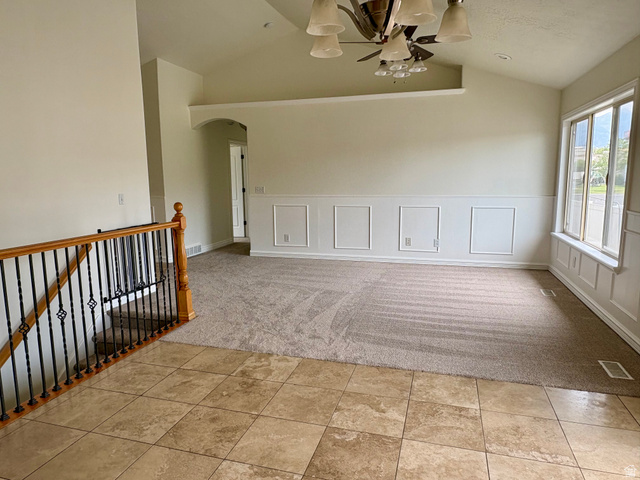 665 West State Road Lehi, UT 84043 - Photo 6 of 30 Vaulted ceilings highlight this living space, featuring a decorative ceiling fan with integrated lighting, wainscoting paneling, and a window with an integrated bench