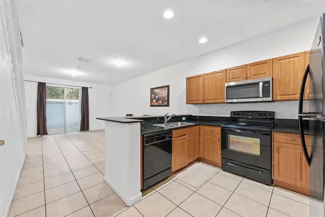 a kitchen with stainless steel appliances granite countertop a stove top oven and sink