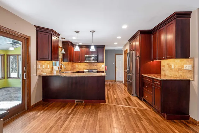 a kitchen with granite countertop wooden floors and stainless steel appliances