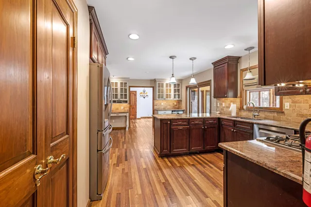 a kitchen with stainless steel appliances granite countertop lots of counter top space and wooden floor