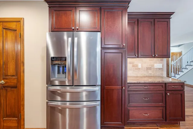 a metallic refrigerator freezer sitting in a kitchen