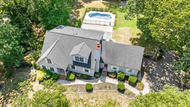 an aerial view of a house with yard and patio