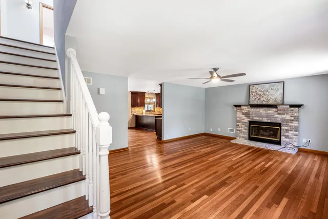 a view of main area wooden floor and fireplace