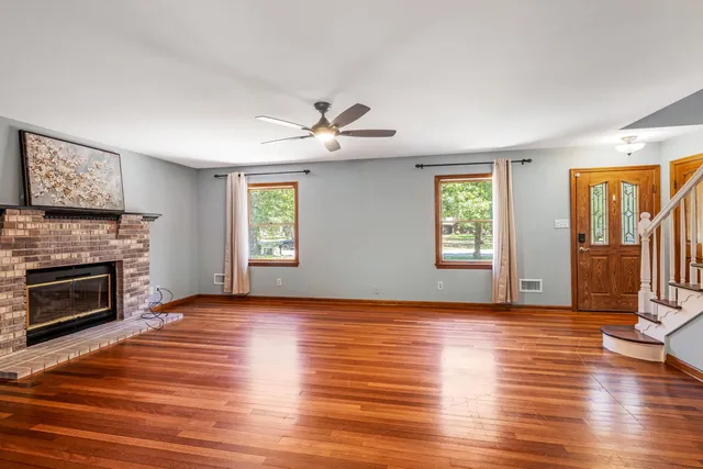 a view of an empty room with window and fire place