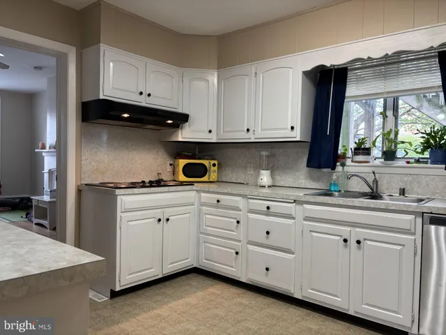 a kitchen with white cabinets and a sink