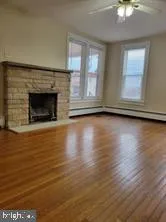 a view of a livingroom with wooden floor a fireplace and window