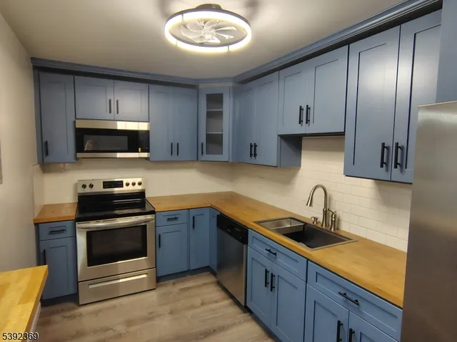 a kitchen with stainless steel appliances granite countertop a sink and a stove top oven