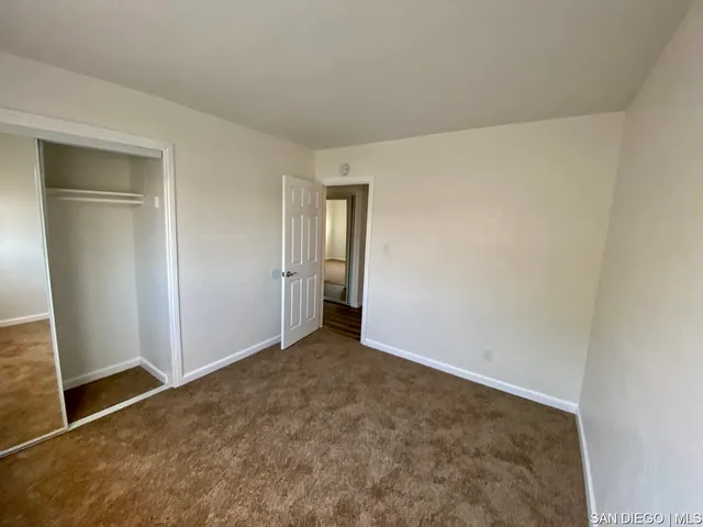 a room with wooden floor and ceiling fan