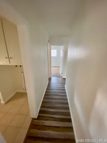 a bedroom with a bed dresser and wooden floor