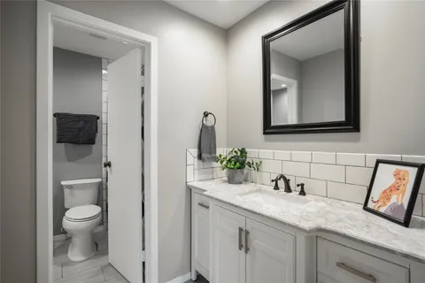 a bathroom with a granite countertop toilet sink and mirror