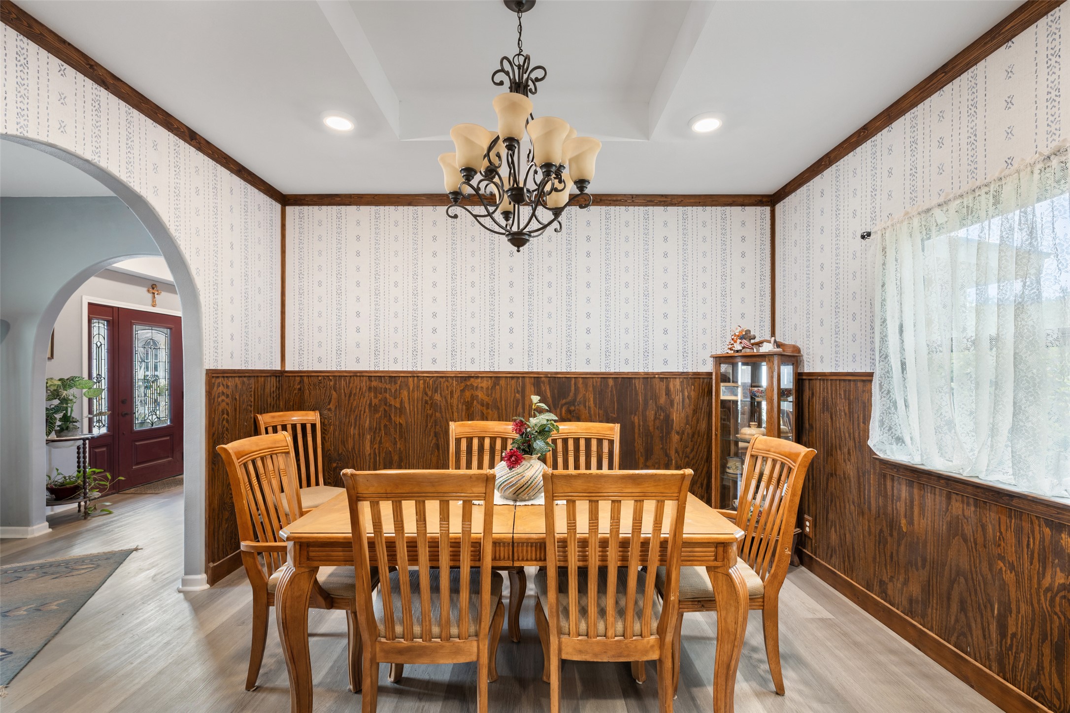 2966 Rm 165 Dripping Springs Dripping Springs, TX 78620 - Photo 9 of 23 Formal dining area featuring wood-finish flooring, half-wall wainscoting, and a decorative coffered ceiling with a central chandelier