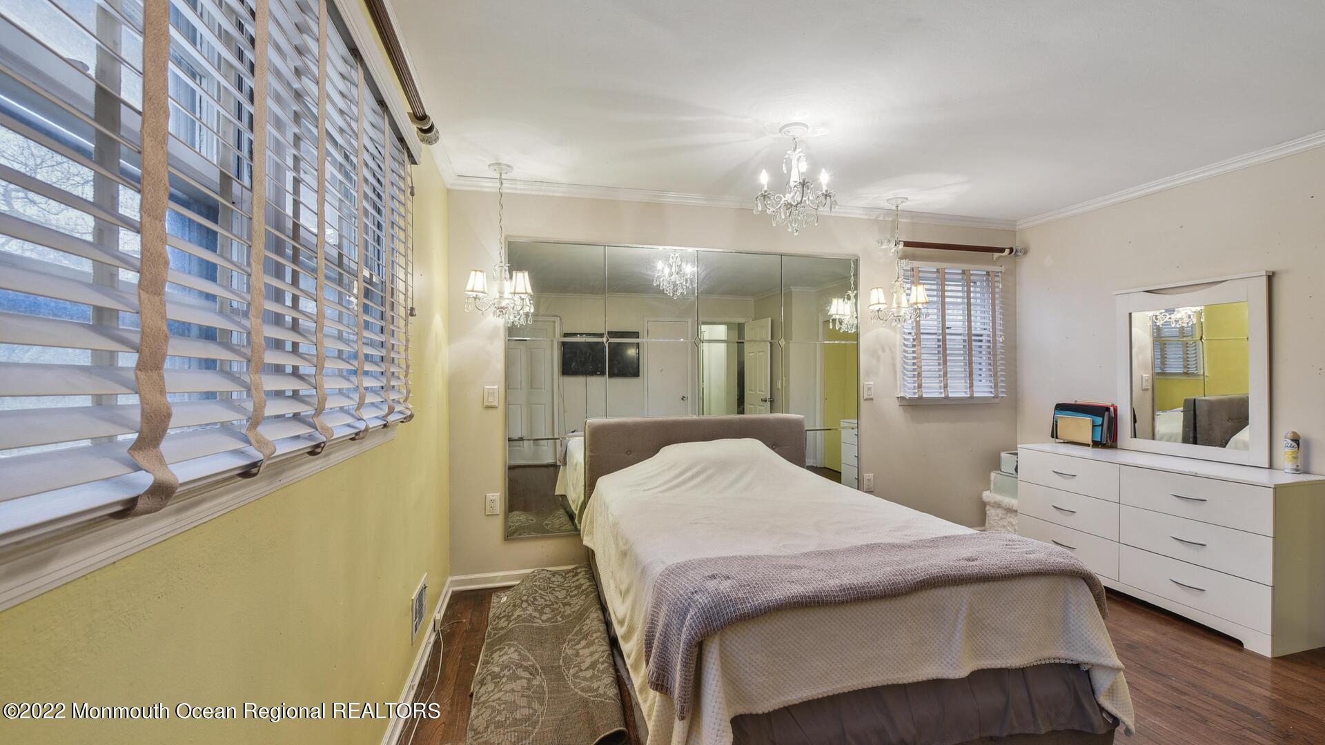 524 Lloyd Road Matawan, NJ 07747 - Photo 15 of 25 a spacious bedroom with a bed and a chandelier