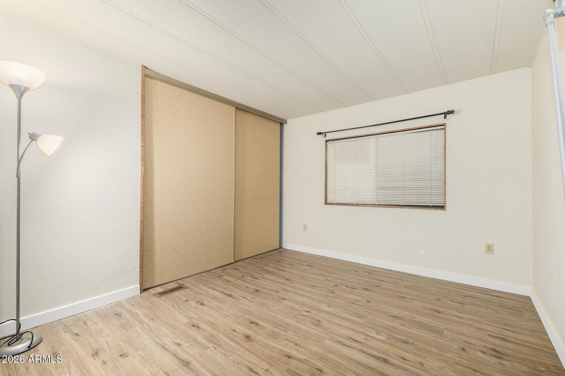 3330 East Main Street, Unit 448 Mesa, AZ 85213 - Photo 20 of 30 a view of an empty room with wooden floor and a window