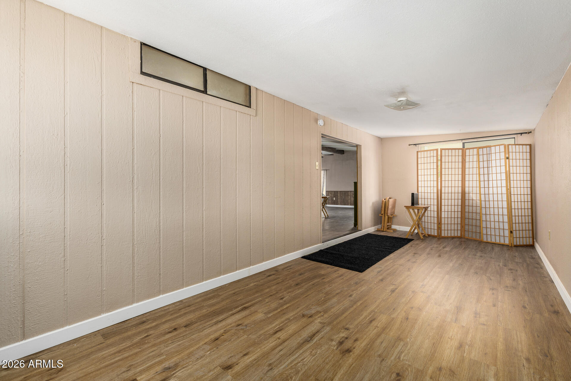 3330 East Main Street, Unit 448 Mesa, AZ 85213 - Photo 8 of 30 a view of an empty room with wooden floor and a window