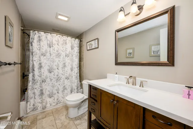 a bathroom with a double vanity sink toilet and a mirror