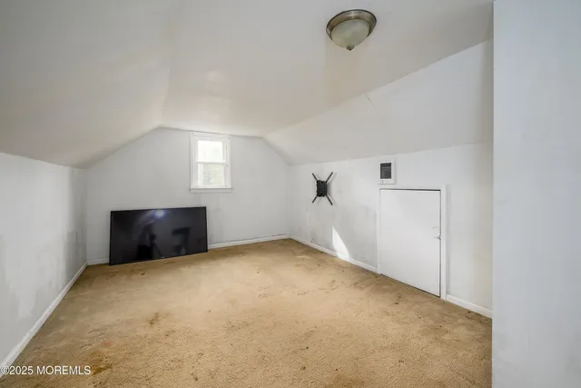an empty room with windows and fireplace