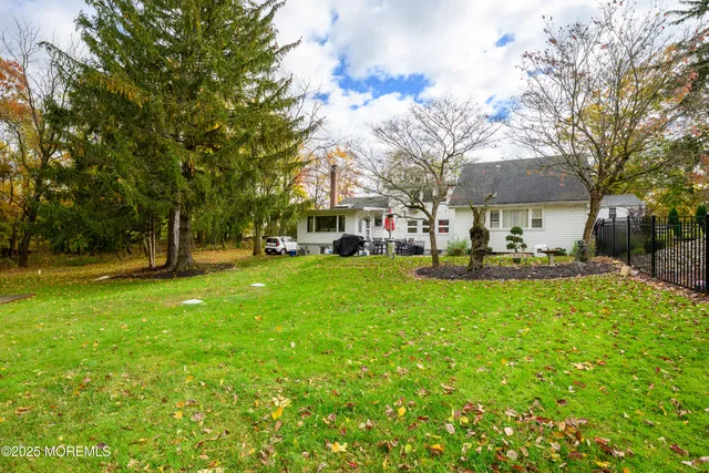 a front view of a building with a garden and trees