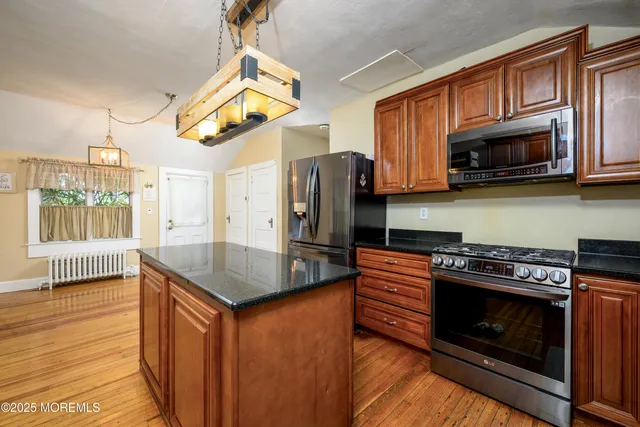 a kitchen with stainless steel appliances granite countertop a stove a refrigerator and a microwave