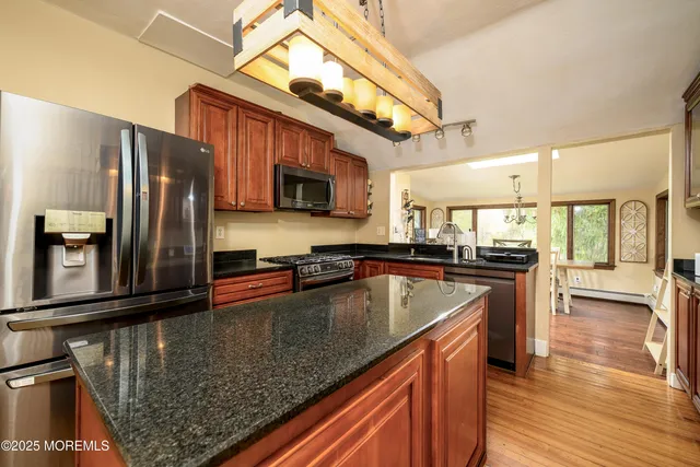 a kitchen with stainless steel appliances granite countertop a sink a stove and a refrigerator