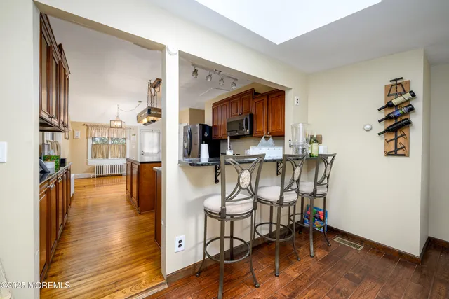 a kitchen with stainless steel appliances a dining table chairs and chandelier