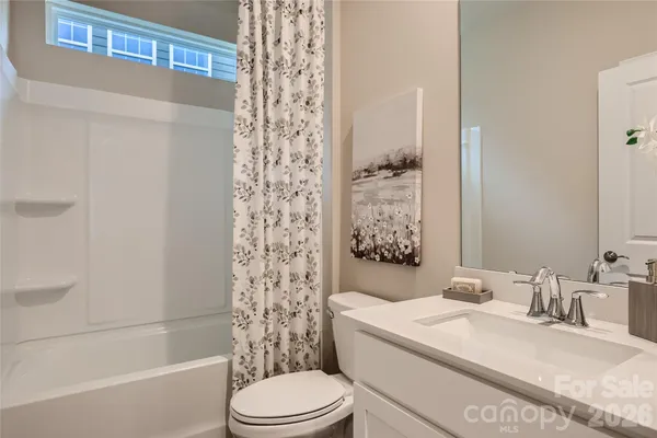 a bathroom with a granite countertop bathtub sink vanity mirror and toilet