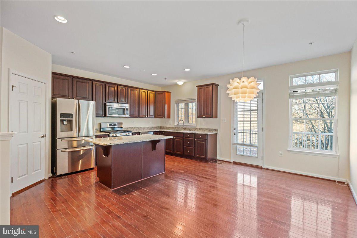 2602 St Marys View Road Accokeek, MD 20607 - Photo 9 of 47 a large kitchen with stainless steel appliances granite countertop a refrigerator a sink dishwasher a oven and a dining table with wooden cabinet