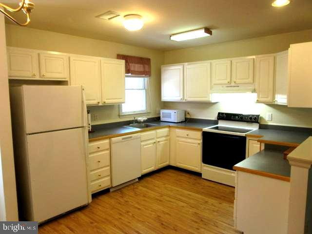 7 East Village Road, Unit 7 Newark, DE 19713 - Photo 3 of 33 a kitchen with sink a refrigerator and white cabinets