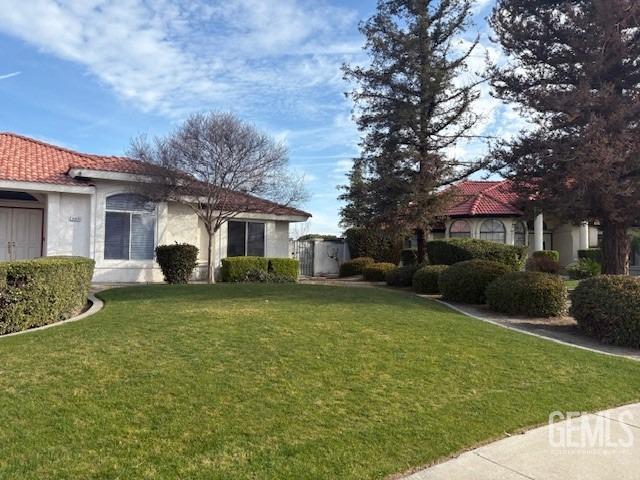 Undisclosed Address Bakersfield, CA 93313 - Photo 2 of 2 a front view of a house with garden