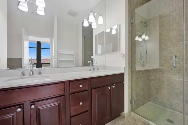 a bathroom with a granite countertop sink a large mirror and a shower