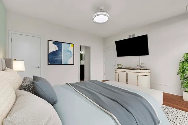 a bedroom with a bed and a flat screen tv