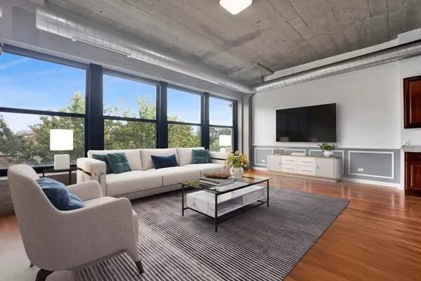 a living room with furniture a flat screen tv and a floor to ceiling window