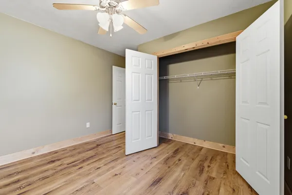 a view of an empty room with wooden floor