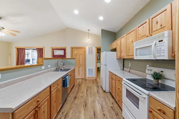 a kitchen with stainless steel appliances granite countertop lots of counter top space and wooden floor