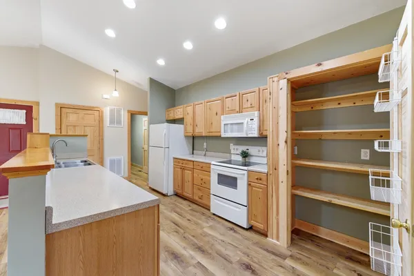 a open kitchen with kitchen island white cabinets and stainless steel appliances