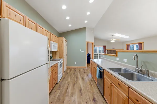 a kitchen with stainless steel appliances granite countertop a sink and a refrigerator