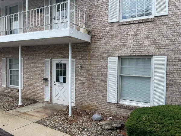 a front view of a house with plants