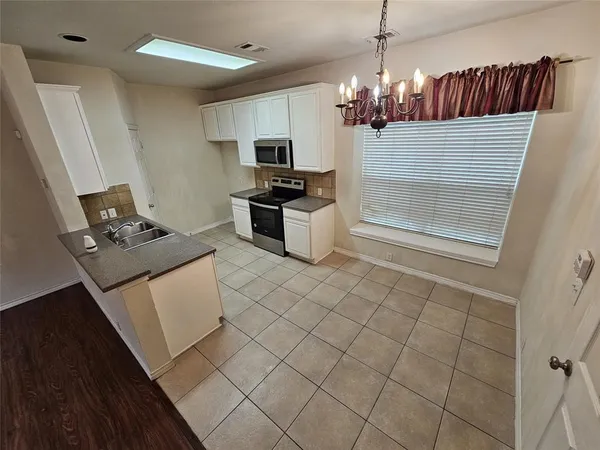 a kitchen with stainless steel appliances kitchen island granite countertop a sink and a stove