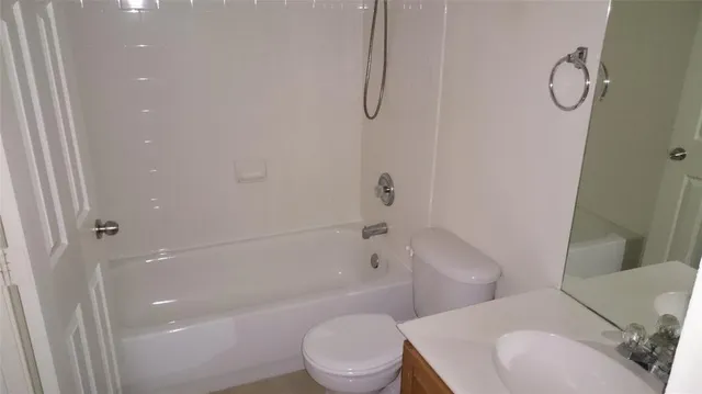 a white toilet sitting next to a bath tub shower