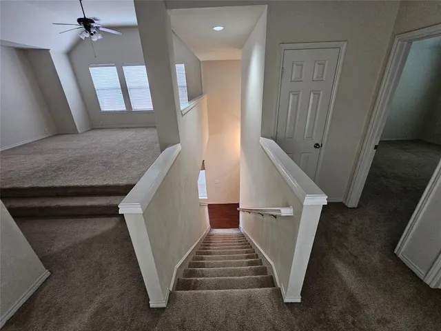 a view of staircase with lots of frames on wall and stairs