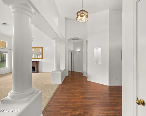 a view of a hallway with wooden floor and a staircase