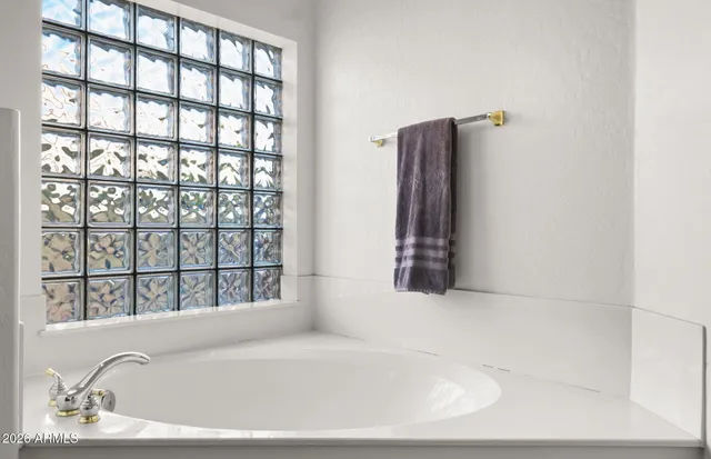 a white bath tub sitting in a bathroom next to a window