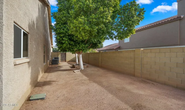 a front view of a house with a garden and trees