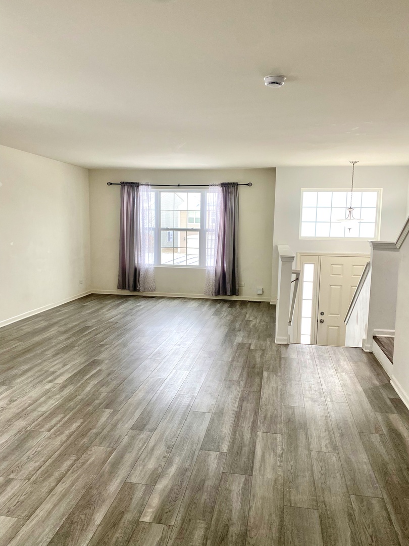 308 Niagara Drive Volo, IL 60073 - Photo 4 of 17 an empty room with wooden floor and windows