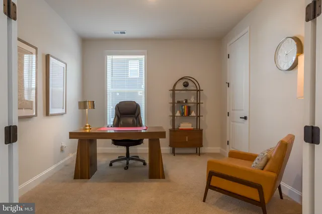 a bedroom with two beds and a large mirror next to a window
