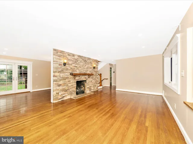 a view of empty room with wooden floor and fireplace