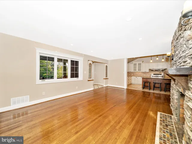a living room with furniture and a dining table with wooden floor