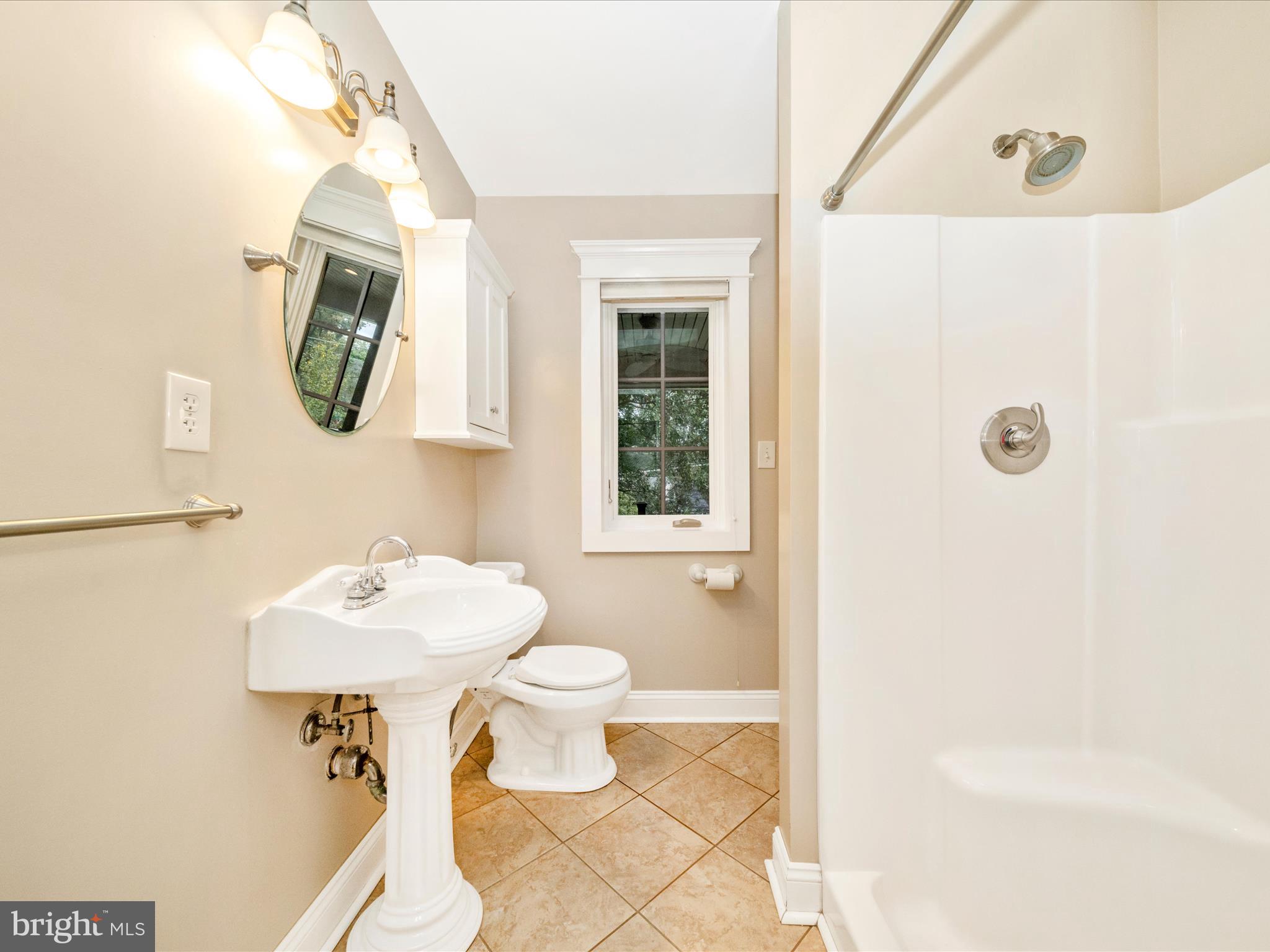 1925 Pagebrook Road Silver Spring, MD 20903 - Photo 30 of 74 a bathroom with a sink a mirror a toilet and a window