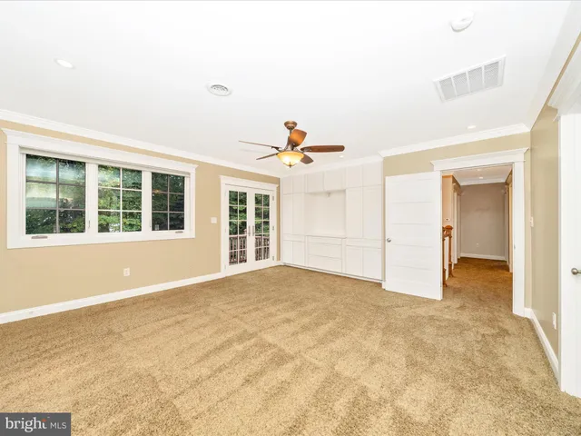 an empty room with window and ceiling fan