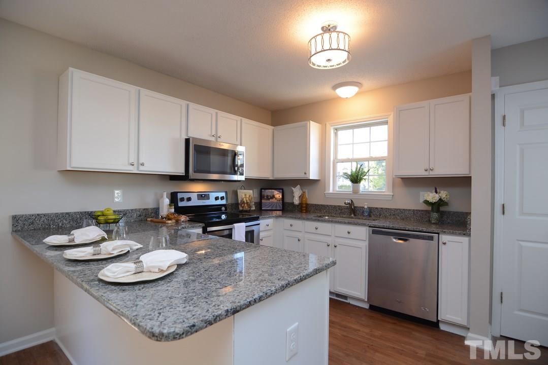 4600 Sinclair Drive Raleigh, NC 27616 - Photo 4 of 25 a kitchen with sink a stove and cabinets