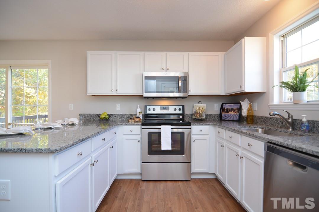 4600 Sinclair Drive Raleigh, NC 27616 - Photo 5 of 25 a kitchen with granite countertop a sink cabinets stainless steel appliances and a window